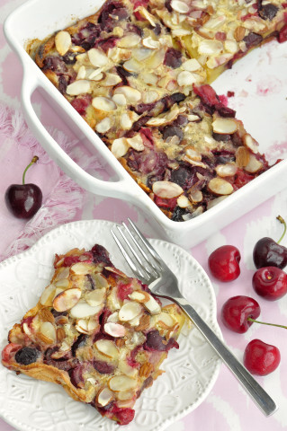 Cherry puff pancake in a pan with a slice of the pancake on the side